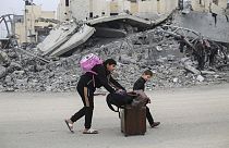 Dos adolescentes palestinos abandonan sus hogares y caminan hacia el sur de la Franja de Gaza en busca de refugio, debido a los bombardeos de Israel.