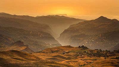 Young cedar trees that have been planted in a forestation initiative, bottom left, are scattered in open land overlooking the Kadisha Valley, northeast Lebanon, 22 July 2023.