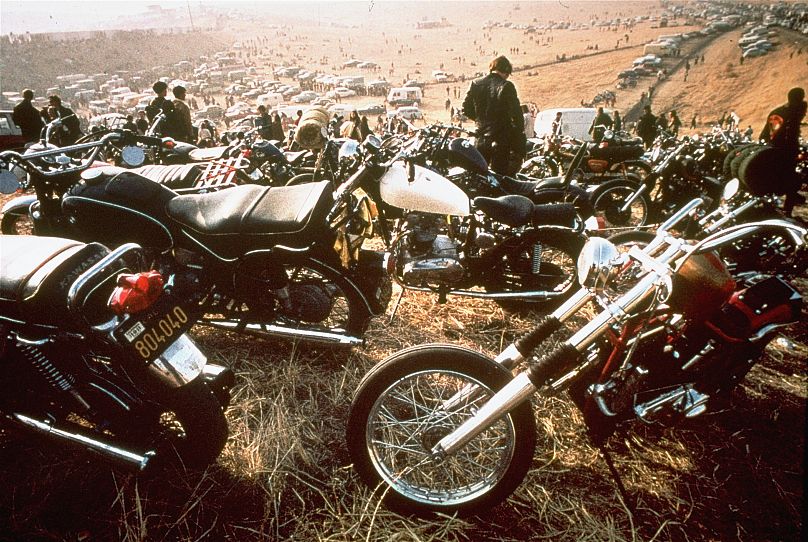 Motorcycles crowd the field at the infamous "Gimme Shelter" rock concert featuring the Rolling Stones.