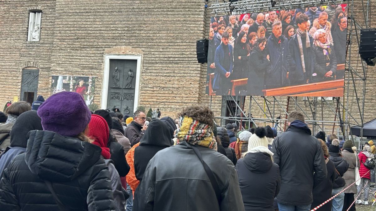 People watch on a screen the funeral of Giulia Cecchettin, outside the Church of Santa Giustina in Padua, Italy, Tuesday Dec. 5, 2023. 