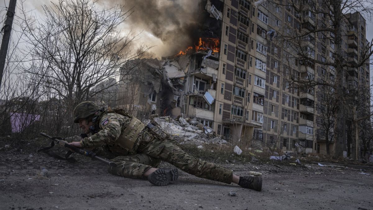 Militar ucraniano protege-se durante bombardeamento russo