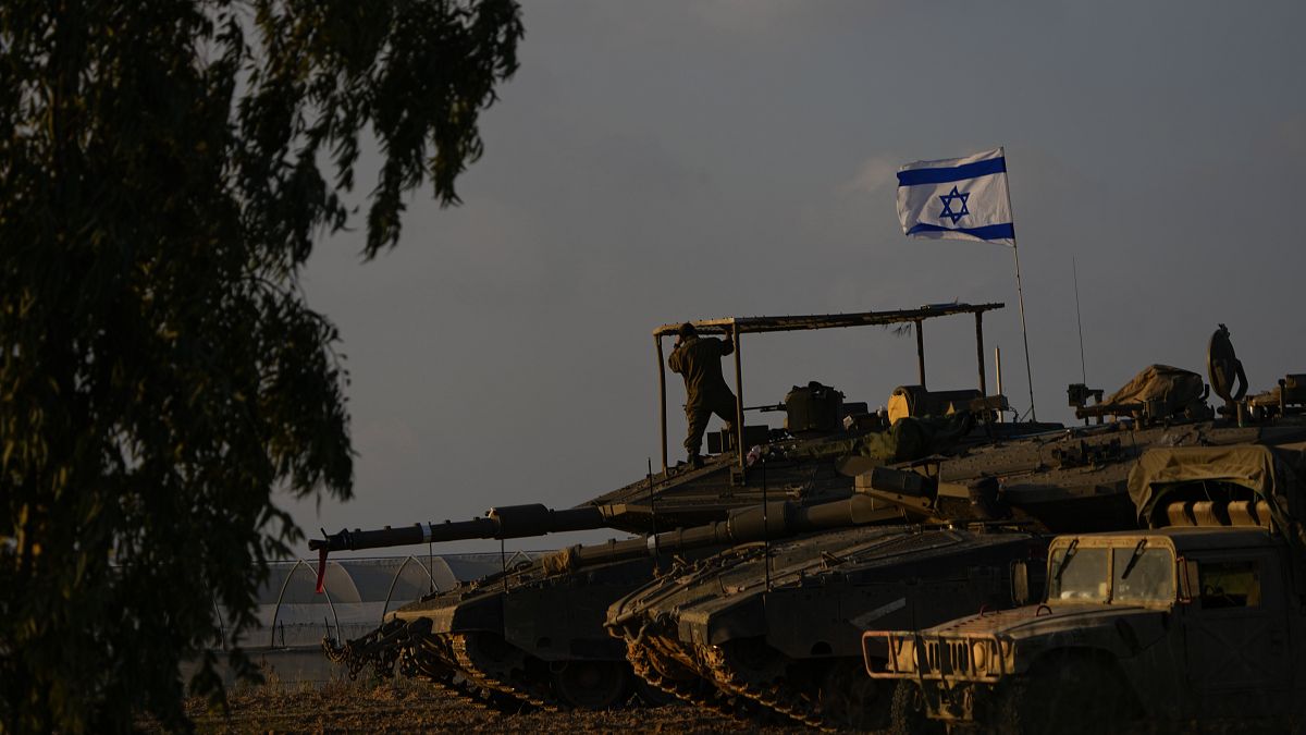 جنود إسرائيليون على متن دبابة في منطقة تجمع للجيش بالقرب من حدود إسرائيل مع غزة، الجمعة 1 ديسمبر 2023.