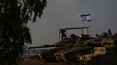 جنود إسرائيليون على متن دبابة في منطقة تجمع للجيش بالقرب من حدود إسرائيل مع غزة، الجمعة 1 ديسمبر 2023.