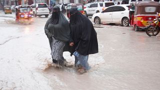 نساء صوماليات يمشين في مقديشو خلال سيل سببته الأمطار الغزيرة