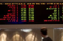 A trader walks past a board at the Tel Aviv Stock Exchange on January 16, 2011.