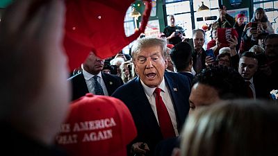 Former President Donald Trump arrives to speak at a Commit to Caucus rally held at Whiskey River on Saturday