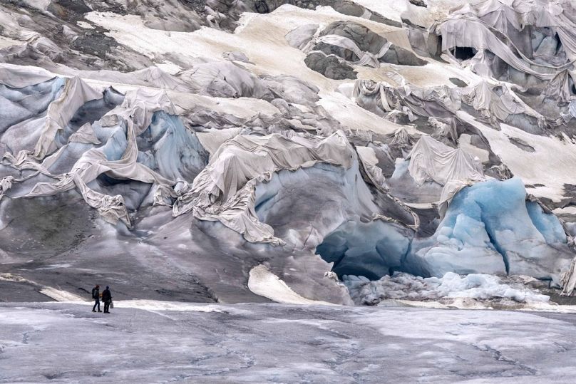 Team members of ETH arrive at the Rhone Glacier partially covered near Goms, Switzerland, June 2023