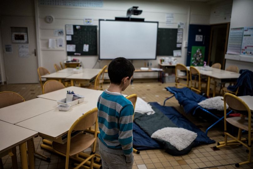 Un enfant s'apprête à dormir dans une classe, le 10/01/2018 à Vaulx-en-Velin, en France, alors que des enseignants et des parents d'élèves accueillent des familles sans-abri