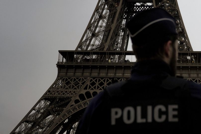 A French policeman patrols near the Eiffel Tower, in Paris, Thursday, Dec. 7, 2023.
