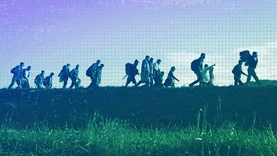 Migrants walk on a dyke after crossing from Croatia, in Brezice, Slovenia, October 2015