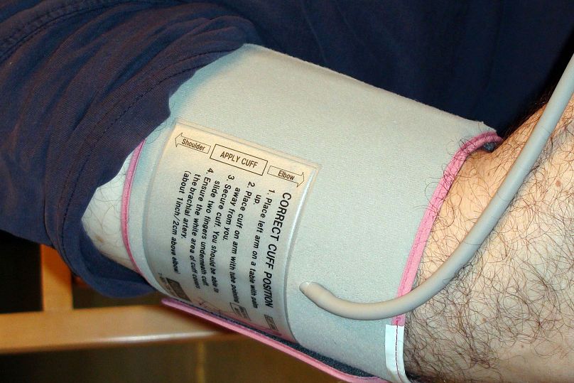 A man wearing a cuff getting a blood pressure reading.