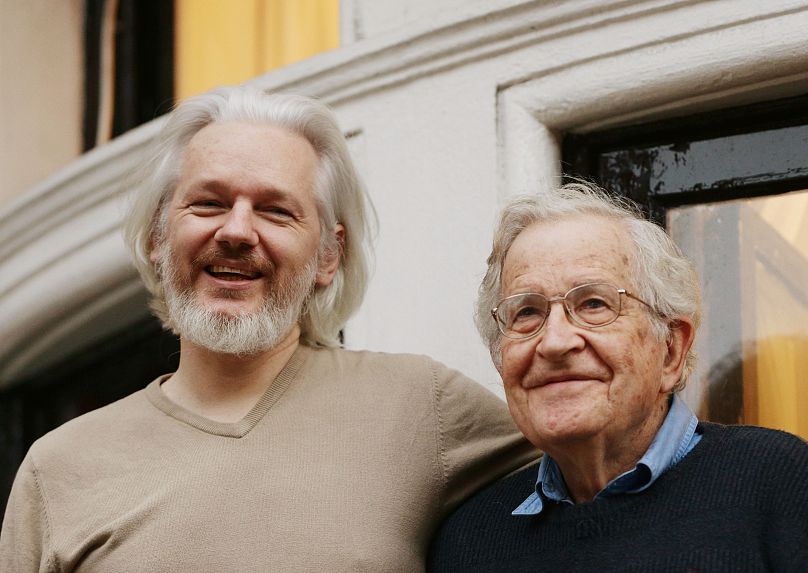 Julian Assange, left, stands with American linguist, philosopher and writer Noam Chomsky
