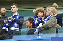 Chelsea owner Roman Abramovich smiles as he holds his son Aaron as his other son Arkadiy looks on at left after the English Premier League soccer match.