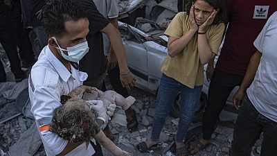 Una niña palestina reacciona cuando sacan a un niño de los escombros de un edificio después de un ataque aéreo en Jan Yunis, Franja de Gaza, el sábado 21 de octubre de 2023.