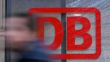 A commuter walks past the logo of German national railway operator Deutsche Bahn DB at the main station of Frankfurt am Main, western Germany.