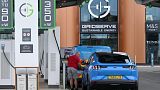 A driver connects their car to a charing point at Gridserve E-charging station for all-electric cars, near Braintree, eastern England on August 8, 2023. Justin TALLIS / AFP