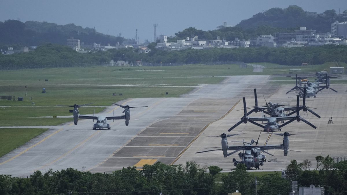 Американский транспортный самолет MV-22B Osprey (слева) выруливает после полета обратно на авиабазу Корпуса морской пехоты США Футенма в Гиноване, к югу от Окинавы, Япония