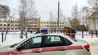 Law enforcement officers stand guard outside Gymnasium Number Five following a shooting, in Bryansk on Thursday
