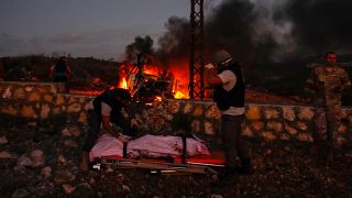 موظفون من الدفاع المدني اللبناني ينقلون جثة الصحافي عصام عبد الله من موقع القصف
