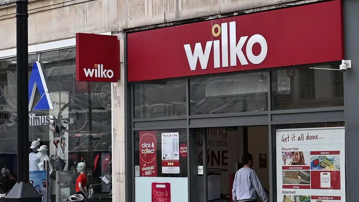 Un ciclista pasa por delante de una sucursal de "Wilko" en el oeste de Londres el 3 de agosto de 2023\. Wilko, 3 de agosto, ha dicho que tiene la intención de nombrar a los administradores, potencialmente poner hasta 12.000 puestos de trabajo.