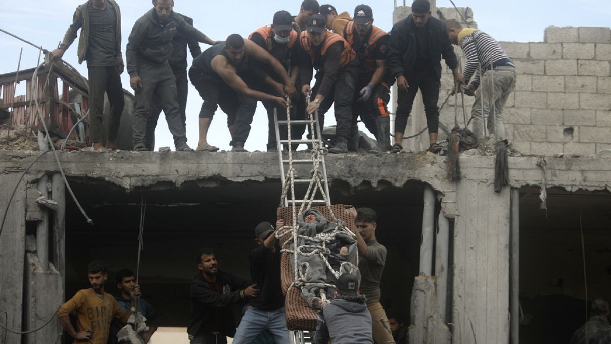 Des Palestiniens sauvent un homme d'un bâtiment détruit suite aux frappes aériennes israéliennes dans le camp de réfugiés de Khan Younis, dans le sud de la bande de Gaza