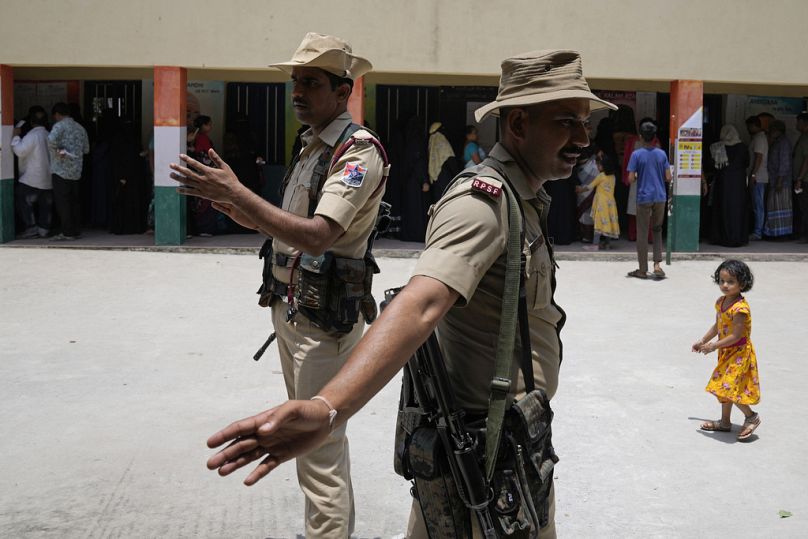 Policemen direct voters to their respective booths at a polling station set up at government run school in Bengaluru, May 2023