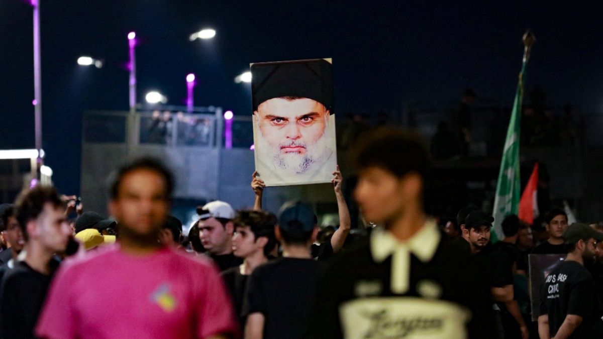 Followers of Iraqi Shiite cleric Moqtada al-Sadr carry his portrait as they protest near Baghdad a day after an alleged burning of the Koran in Copenhagen in July