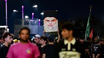 Followers of Iraqi Shiite cleric Moqtada al-Sadr carry his portrait as they protest near Baghdad a day after an alleged burning of the Koran in Copenhagen in July