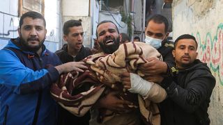 فلسطيني يحمل جثة طفل قتل في القصف الإسرائيلي