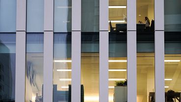 A worker sits in an office in the financial district in London