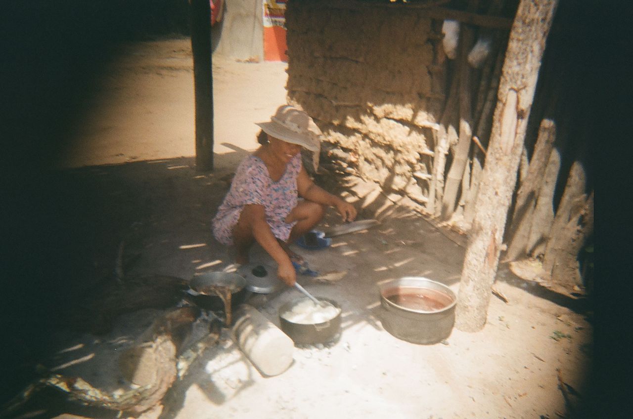 Ismael, 14, takes a picture of his mother cooking in the community.