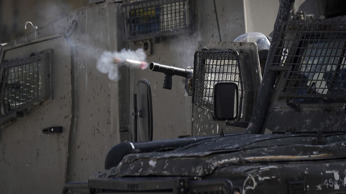ضابط إسرائيلي يطلق الغاز المسيل للدموع على فلسطينيين خلال عملية عسكرية في مخيم بلاطة للاجئين بالضفة الغربية.