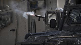 ضابط إسرائيلي يطلق الغاز المسيل للدموع على فلسطينيين خلال عملية عسكرية في مخيم بلاطة للاجئين بالضفة الغربية.