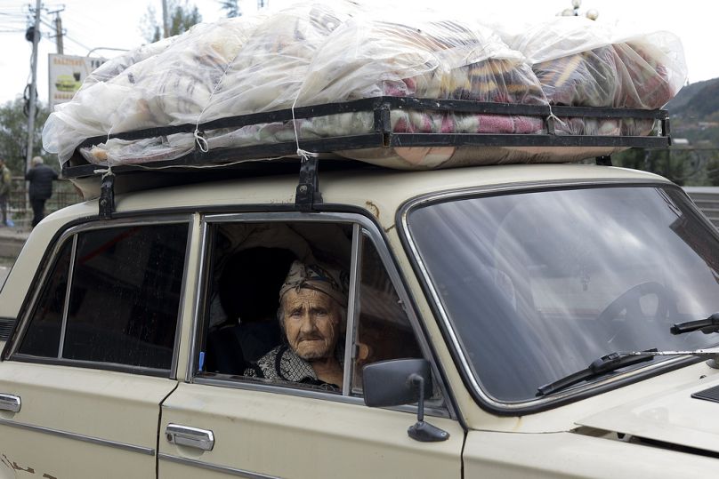 An ethnic Armenian woman from Nagorno-Karabakh sits inside an old Soviet style car as she arrives in Goris, in Armenia's Syunik region, Wednesday, Sept. 27, 2023.
