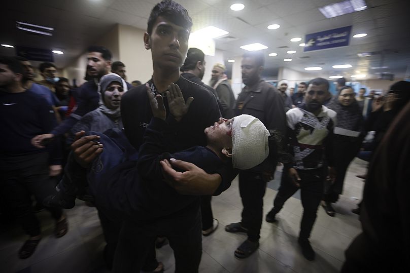 Sebesült gyerek a testvére karjában Hán Júnisz kórházában