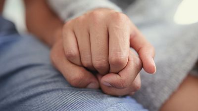 Two people holding hands. 