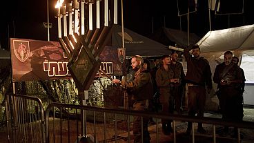  Israeli soldiers from the Givati Brigade mark the first night of the Jewish holiday of Hanukkah by lighting the first candle on their base in southern Israel