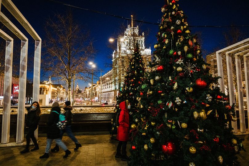 Passers-by walk past decorated Christmas trees in Moscow on December 6, 2020, amid the crisis linked with the Covid-19 pandemic caused by the novel coronavirus. Russia confirm