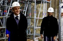 French President Emmanuel Macron (L) walks inside the nave during a visit of the reconstruction work at the Notre-Dame de Paris Cathedral.