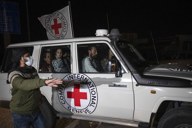 A Red Cross vehicle carrying Israeli hostages drives by at the Gaza Strip crossing into Egypt in Rafah, November 2023