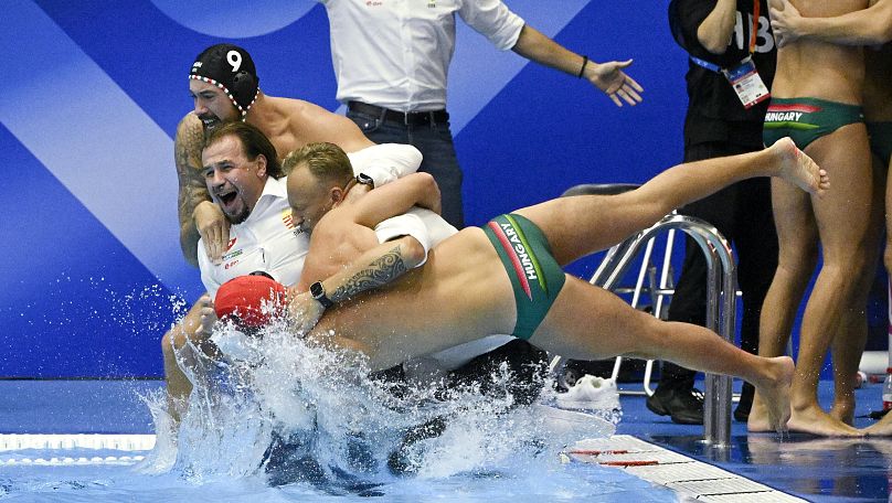 Varga Zsolt szövetségi kapitánnyal és Nyéki Balázs másodedzővel vízbe ugró magyar játékosok a férfi vízilabda vb-döntő után Fukuokában 2023. július 29-én.