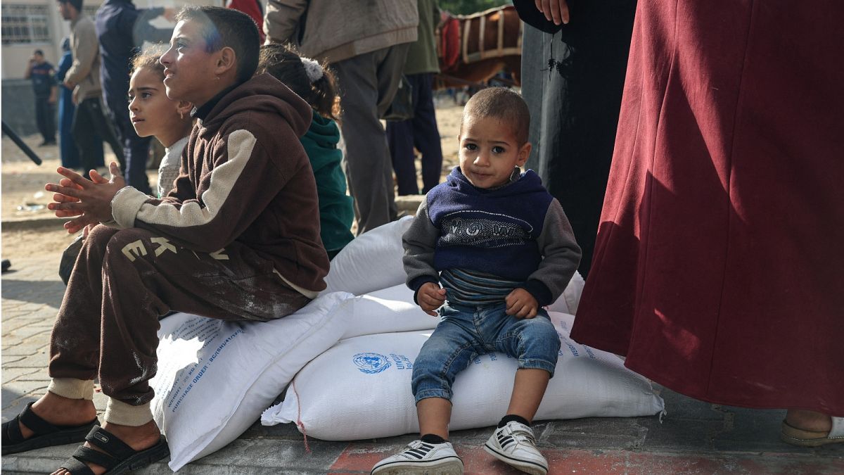 فلسطينيون يتسلمون أكياس الطحين في مركز التوزيع التابع لوكالة الأمم المتحدة لإغاثة وتشغيل اللاجئين الفلسطينيين (الأونروا) في مخيم رفح للاجئين في جنوب قطاع غزة في 21 نوفمبر 2023