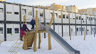 Crianças brincam num parque numa cidade modular para refugiados de regiões ucranianas atingidas pela guerra, em Lviv, na Ucrânia, em fevereiro.