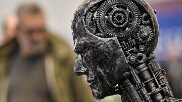 Una testa metallica composta di parti di motore simboleggia l'intelligenza artificiale all'Essen Motor Show in Germania (29 novembre 2019)