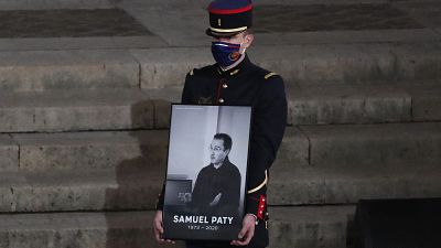 جندي فرنسي يحمل صورة لصموئيل باتي خلال حفل تذكاري في جامعة السوربون، باريس فرنسا