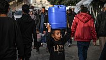 A child is seen as Palestinians meet their water needs from mobile tanks after great damage to the city's infrastructure due to Israeli attacks in Khan Yunis, Gaza 