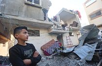 A young boy looks on as Palestinians check the damage following Israeli bombardment on Khan Yunis in the southern Gaza Strip 