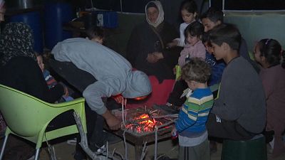 في الليل عندما تنخفض درجات الحرارة، يجبر الطقس البارد العائلات على التجمع حول النار التي أشعلوها بالحطب لتدفئة أنفسهم، مخيم مواسي, غزة 8 دجنبر 2023