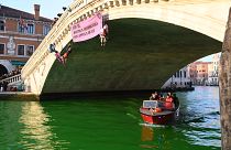 نشطاء حركة التمرد ضد الانقراض (XR) على جسر ريالتو في البندقية بعد صب الفلورسين في القناة الكبرى للإحتجاج على "فشل" مؤتمر (COP28) بشأن المناخ،  البندقية، إيطاليا 9 ديسمبر 2023.
