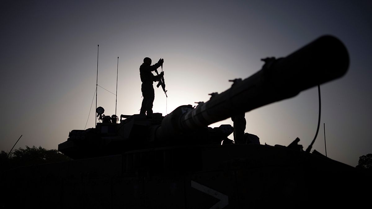 Un soldado armado encima de un tanque en Gaza.
